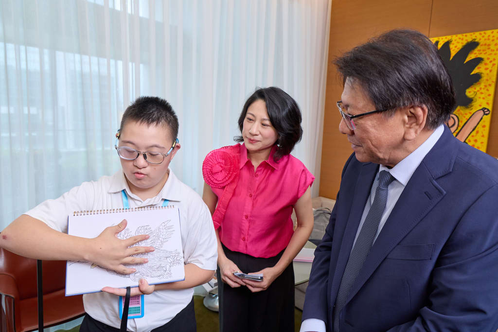 總統府秘書長潘孟安(右)於開幕典禮前參觀兒少藝術展間,在Arteen Taipei創辦人暨策展人王貞懿(中)陪同下,聆聽公益展間參展生分享創作與手稿,近距離了解孩子的藝術世界。圖/墨兒藝術提供